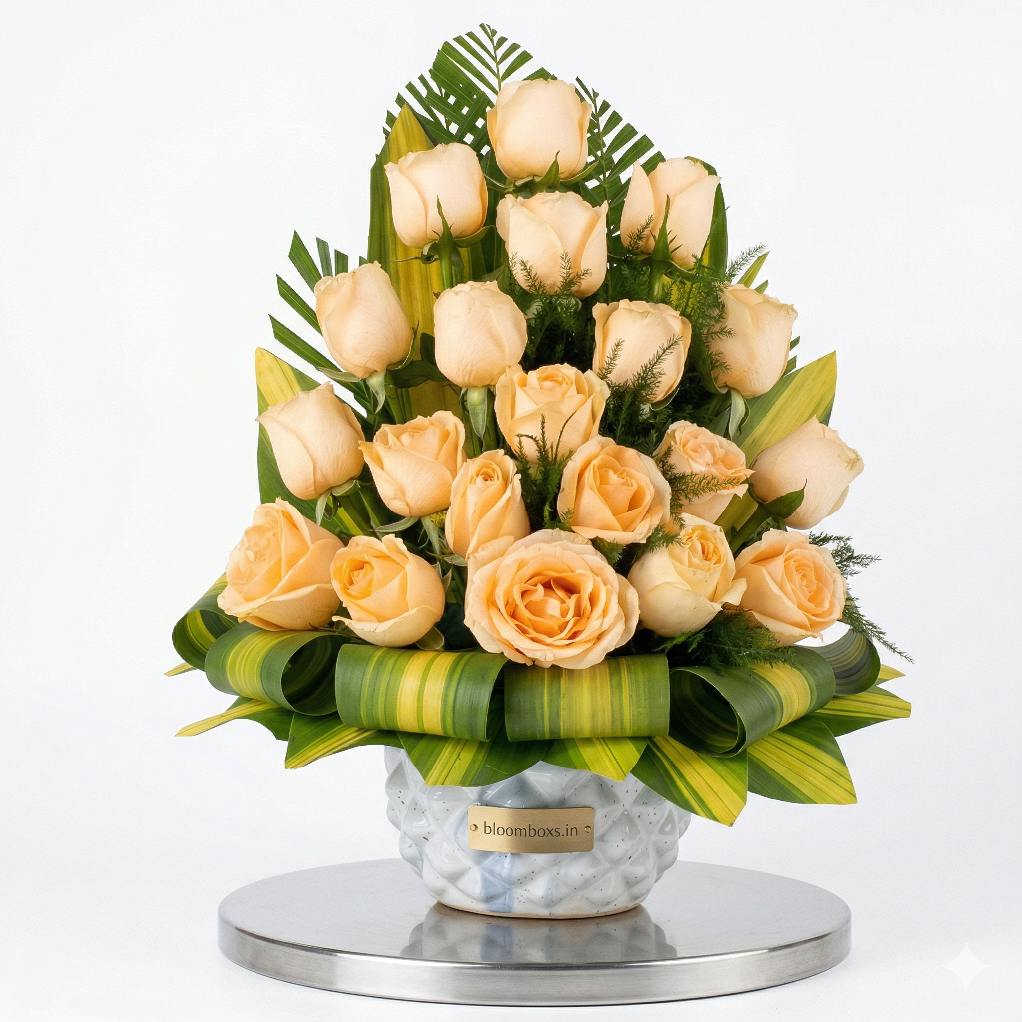 Elevate your gifting and décor experience with this stunning arrangement of fresh peach roses, thoughtfully designed in a premium ceramic vase. The bouquet features a graceful pyramid-style arrangement of handpicked roses, complemented by lush green foliage for a rich and elegant look.

Perfect for birthdays, anniversaries, housewarmings, or simply to brighten someone’s day, this floral arrangement creates a soothing and luxurious vibe wherever placed. The soft peach tones symbolize gratitude, admiration, a