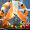 Decorative Ganesha idol with vibrant flowers and fruits during a traditional Indian festival in Bengaluru, India.