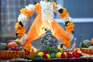 Decorative Ganesha idol with vibrant flowers and fruits during a traditional Indian festival in Bengaluru, India.